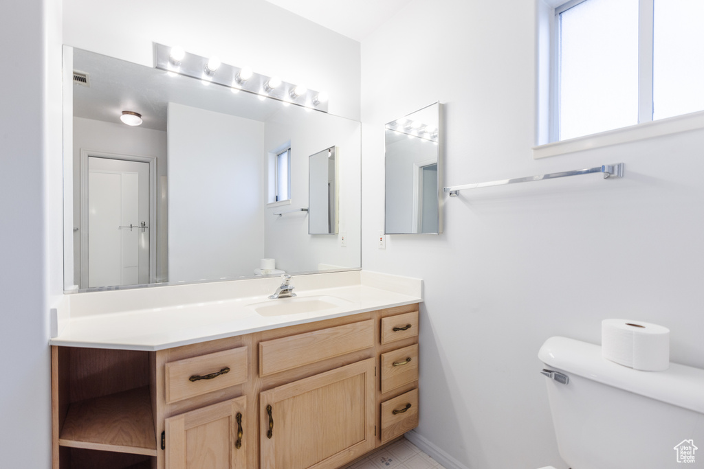 Bathroom featuring vanity, toilet, and tile floors