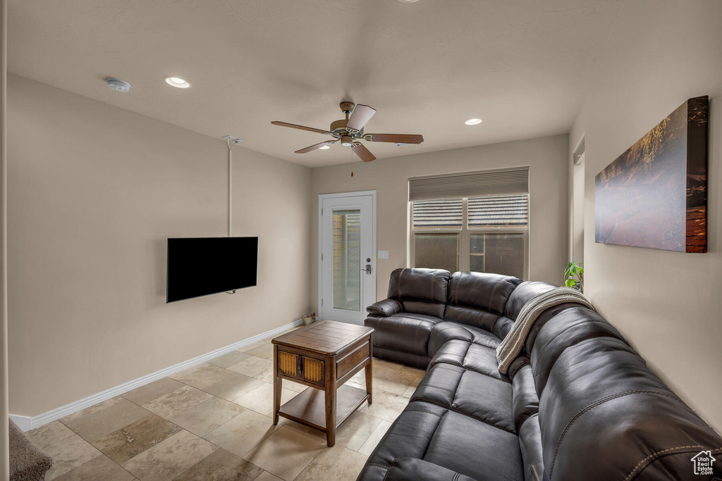 Living room featuring light tile flooring and ceiling fan