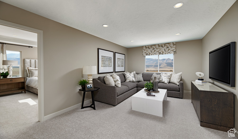 Living room with a wealth of natural light, light colored carpet, and a mountain view