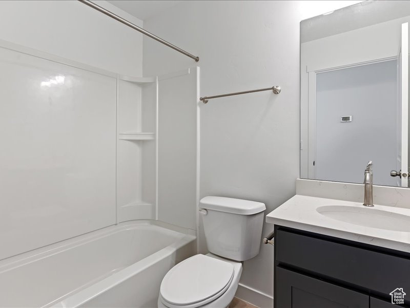 Full bathroom with toilet, vanity, and washtub / shower combination