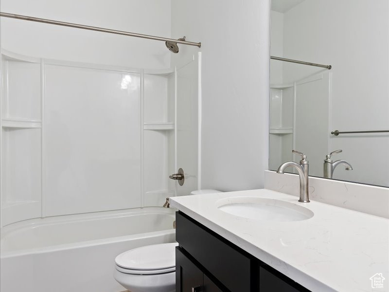 Full bathroom with vanity, shower / bath combination, and toilet