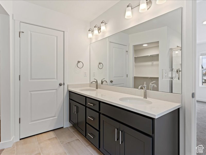 Bathroom with tile floors, double sink, and large vanity