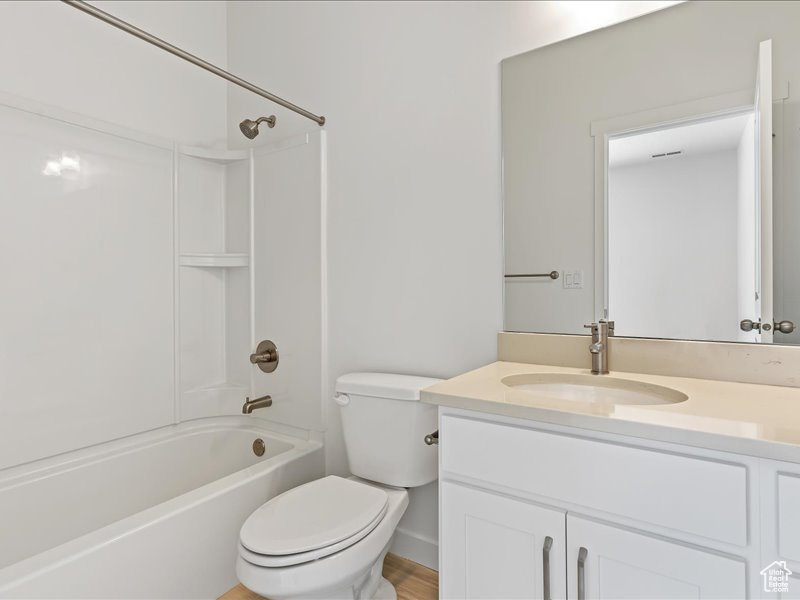 Full bathroom featuring oversized vanity, bathtub / shower combination, and toilet