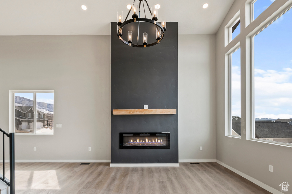 Interior space with a fireplace, a notable chandelier, and light hardwood / wood-style floors