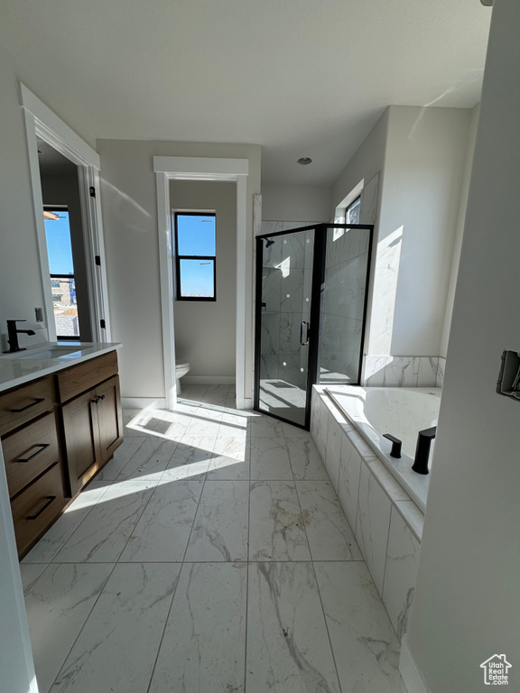 Full bathroom featuring toilet, tile flooring, plus walk in shower, and vanity