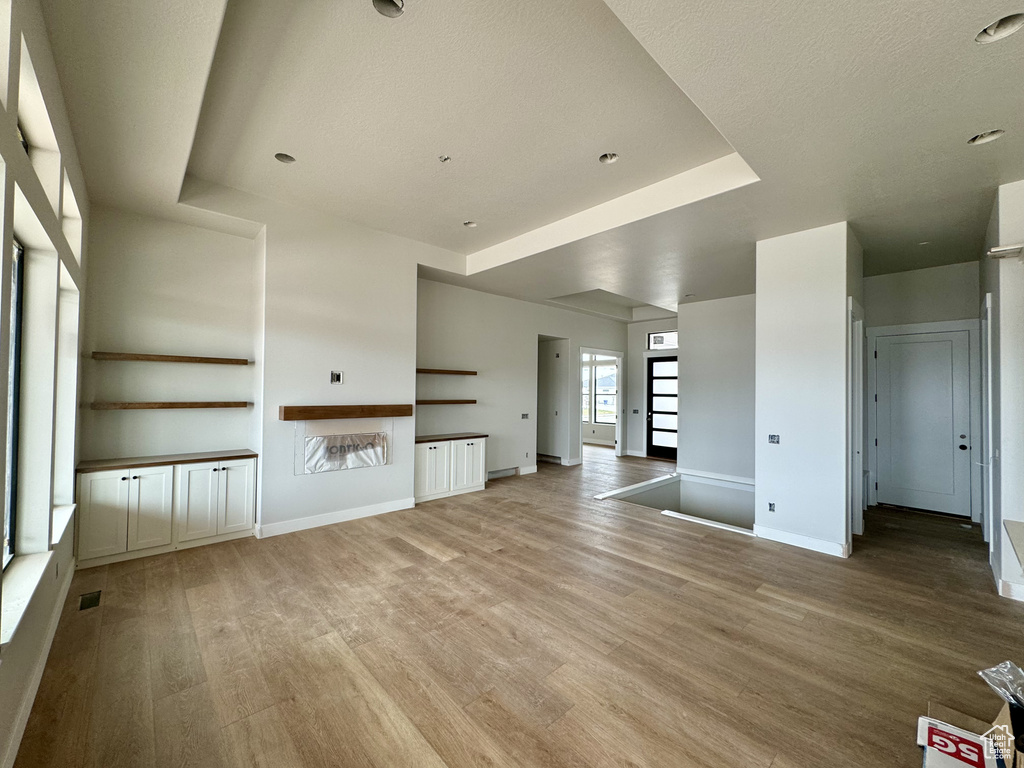 Empty room featuring light hardwood / wood-style floors and a tray ceiling