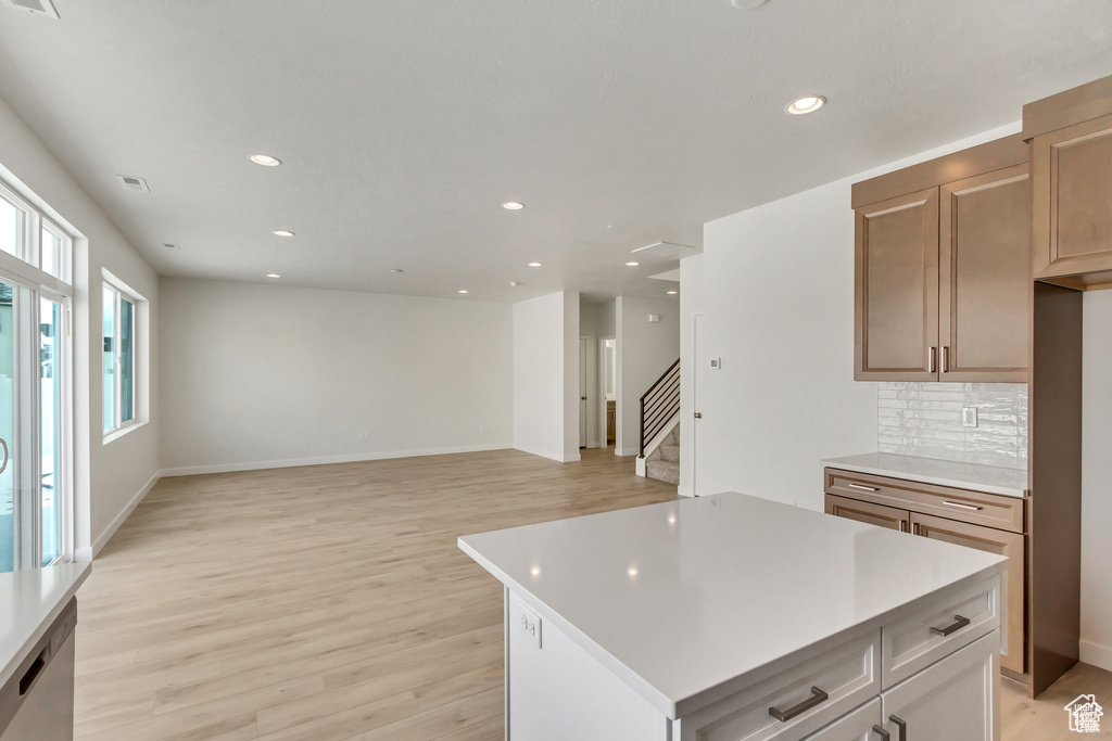 Kitchen featuring tasteful backsplash, light brown cabinets, a center island, and light hardwood / wood-style floors