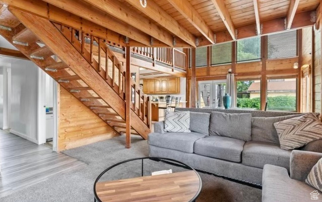 Living room with beamed ceiling, light hardwood / wood-style flooring, and wood ceiling