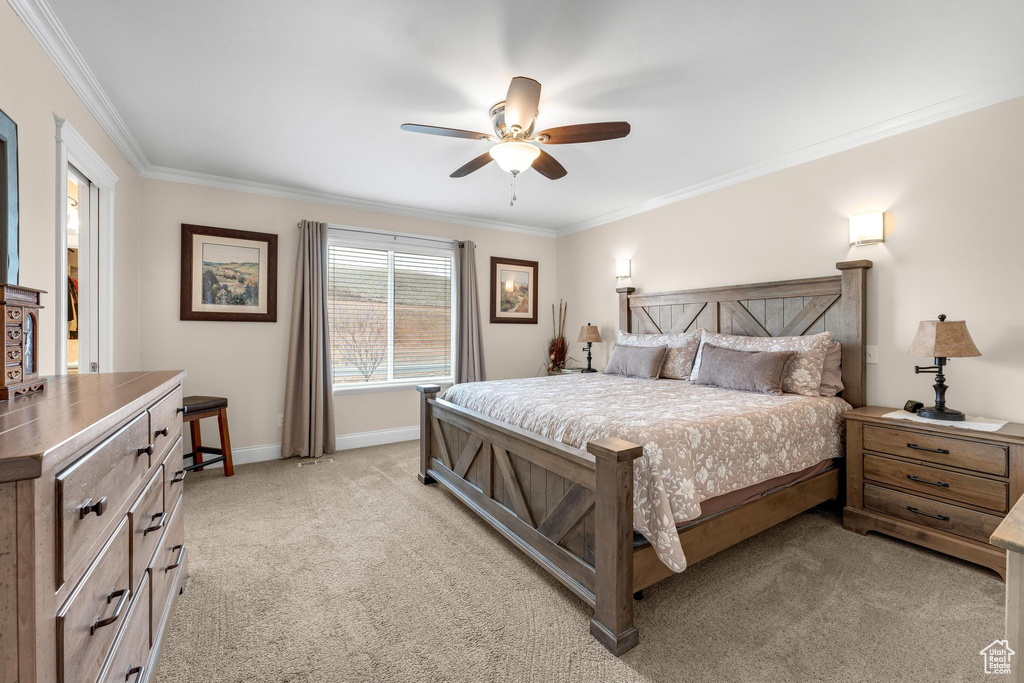 Bedroom featuring ornamental molding, light carpet, and ceiling fan