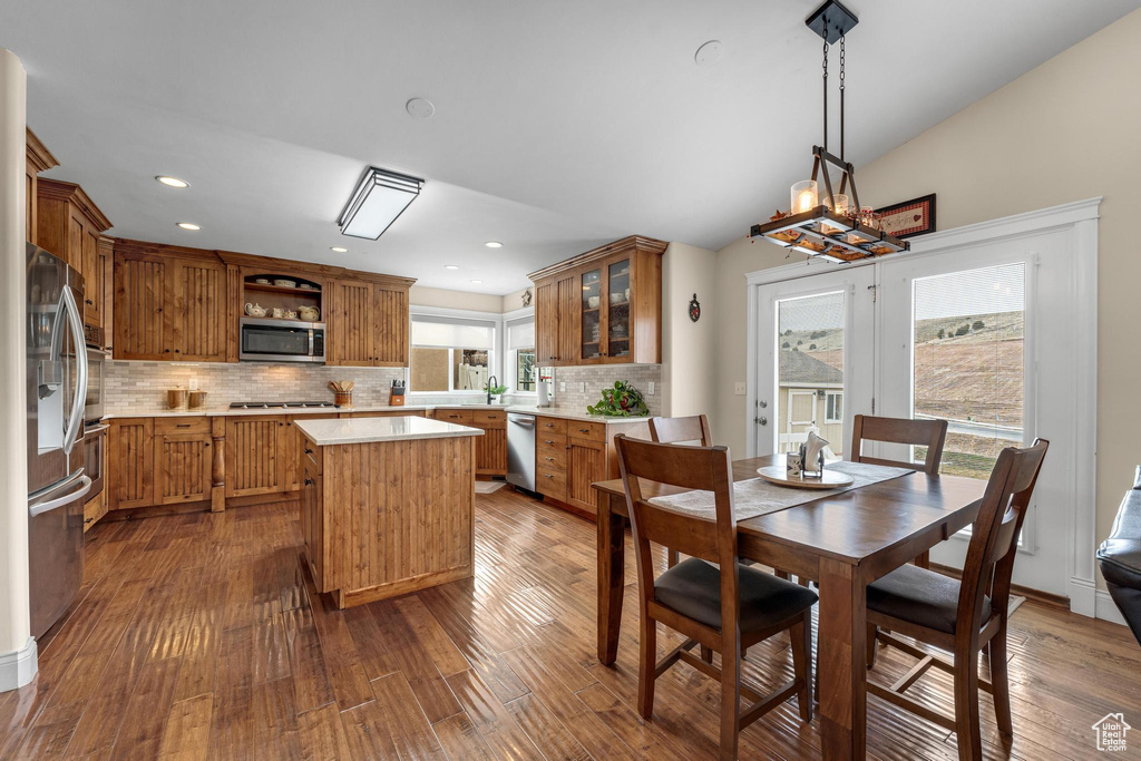 Kitchen featuring dark wood-type flooring, stainless steel appliances, and tasteful backsplash