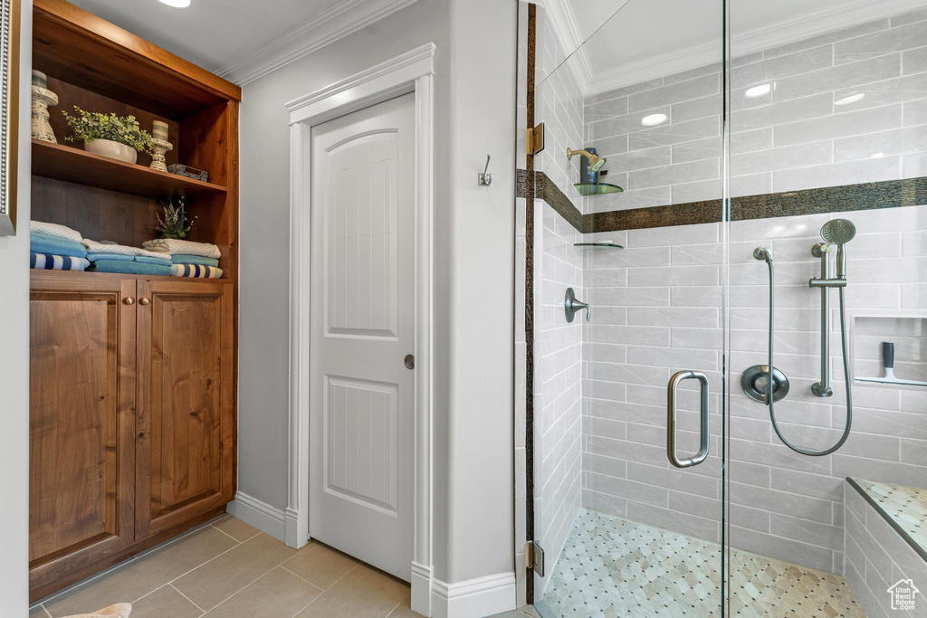 Bathroom featuring walk in shower, tile floors, and crown molding