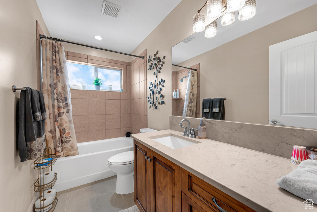 Full bathroom featuring vanity, toilet, tile flooring, and shower / bath combo with shower curtain