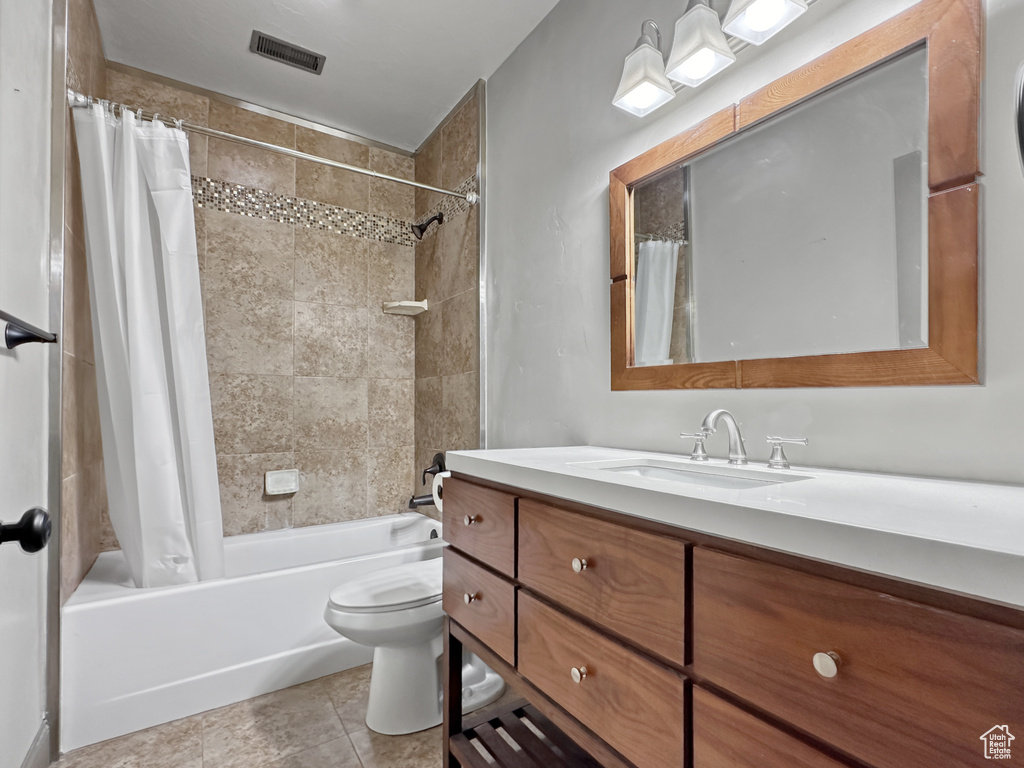 Full bathroom featuring shower / tub combo, toilet, large vanity, and tile floors