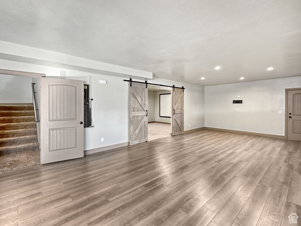 Basement featuring light hardwood / wood-style flooring and a barn door