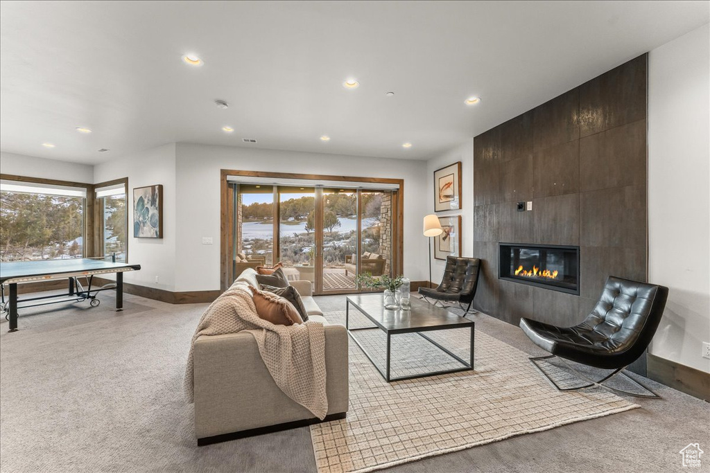 Carpeted living room with plenty of natural light and a tile fireplace