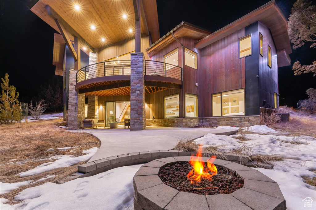Exterior space with an outdoor fire pit and a balcony