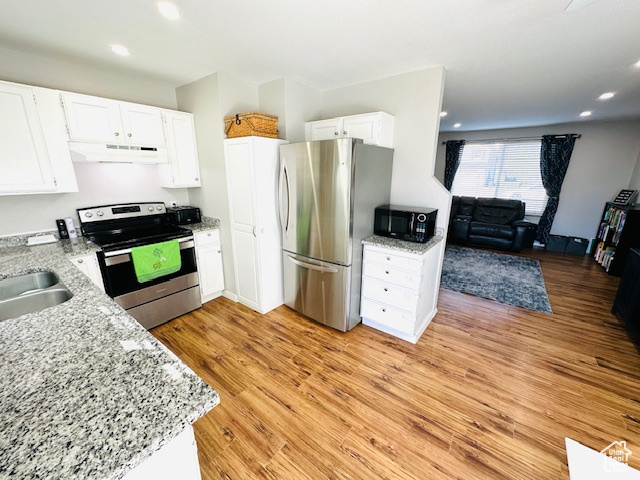 Kitchen featuring extractor fan, white cabinets, stainless steel appliances, and light hardwood / wood-style floors