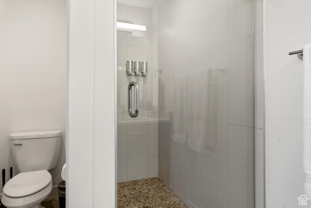 Bathroom with a shower with shower door and toilet