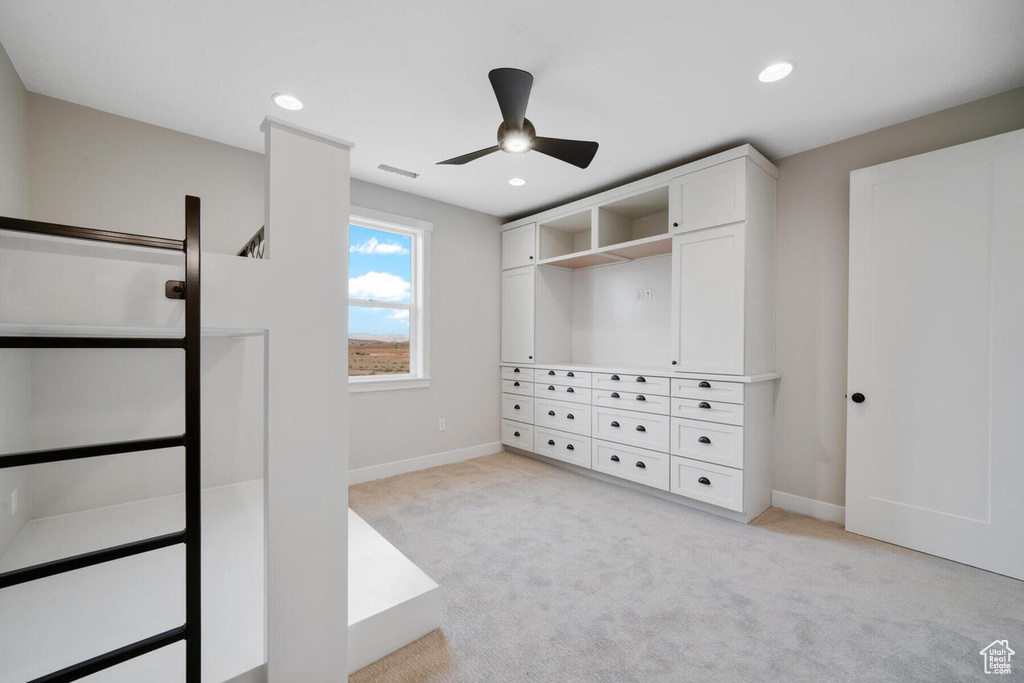 Walk in closet featuring light colored carpet and ceiling fan