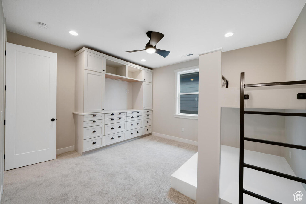 Spacious closet featuring light carpet and ceiling fan