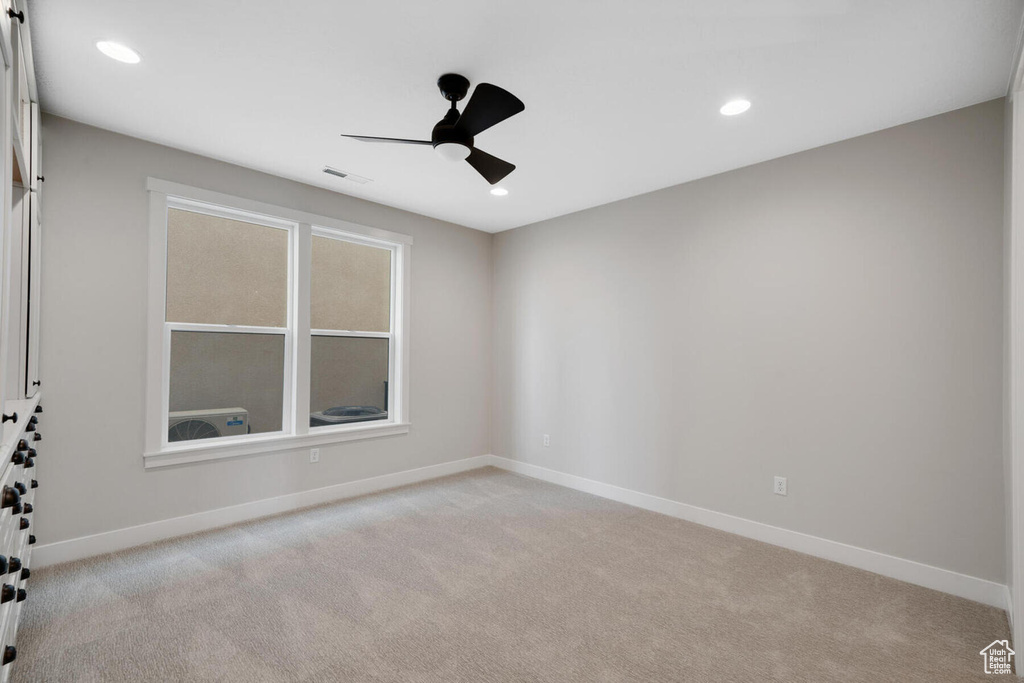 Carpeted spare room featuring ceiling fan