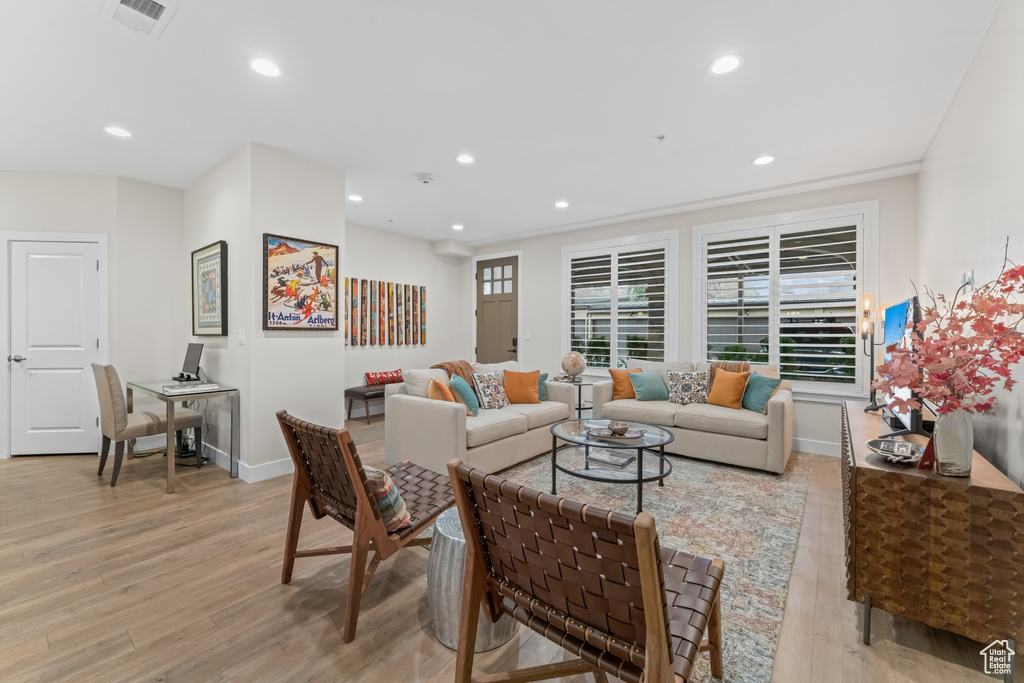 Living room featuring ornamental molding and light hardwood / wood-style floors