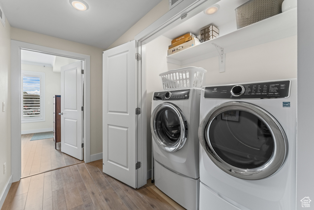 Laundry area featuring light wood-type flooring and independent washer and dryer