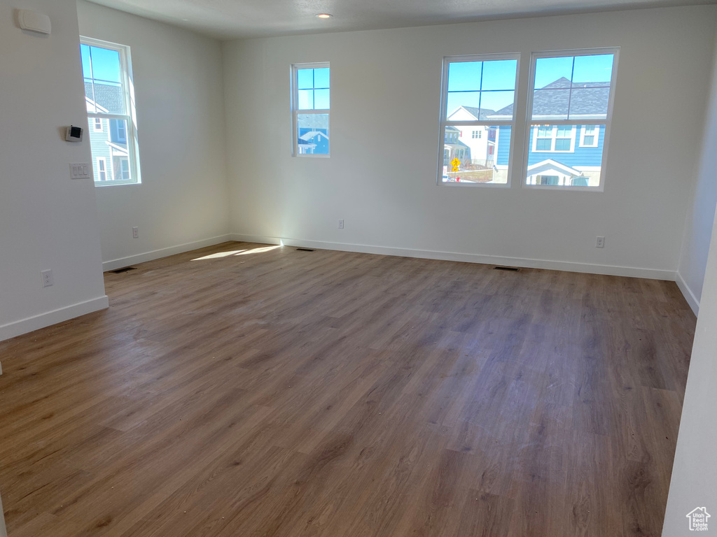 Unfurnished room featuring a wealth of natural light and dark hardwood / wood-style floors