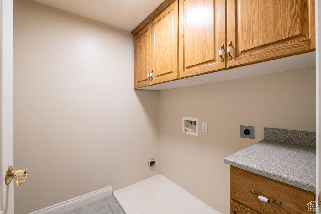 Laundry room with washer hookup, light tile floors, hookup for an electric dryer, and cabinets