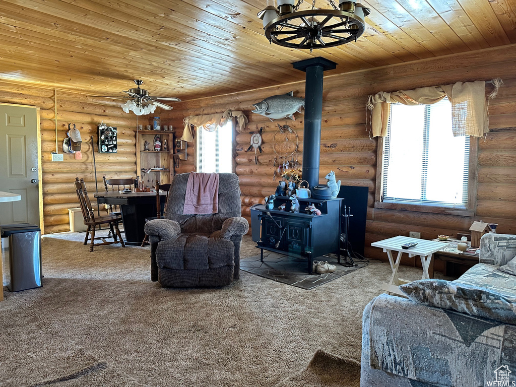 Living room with a wood stove, rustic walls, and carpet floors