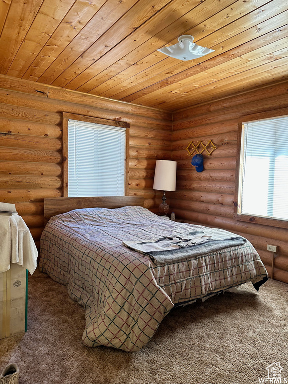Carpeted bedroom with wood ceiling and rustic walls