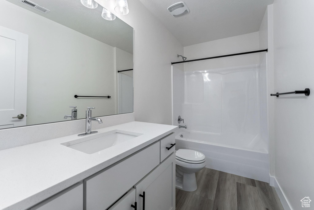 Full bathroom featuring shower / bathing tub combination, hardwood / wood-style flooring, toilet, and vanity