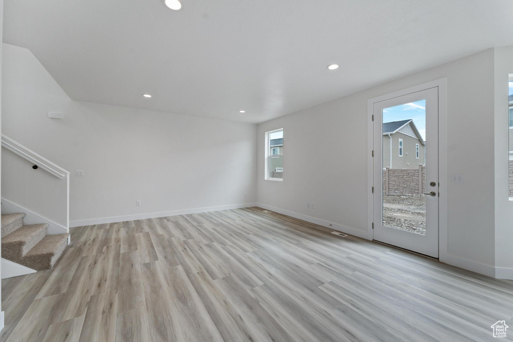 Empty room featuring a healthy amount of sunlight and light hardwood / wood-style flooring