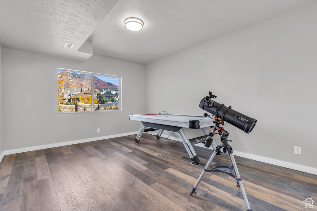 Workout area with dark hardwood / wood-style flooring and a textured ceiling