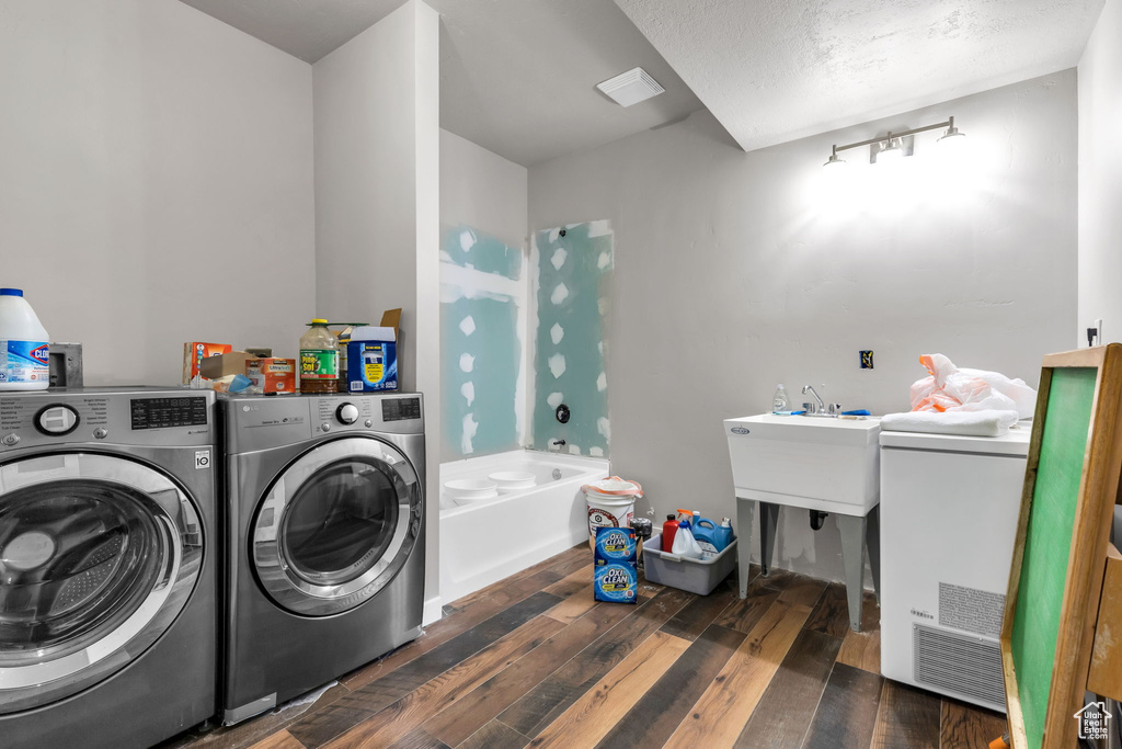 Laundry room with dark wood-type flooring and washer and clothes dryer