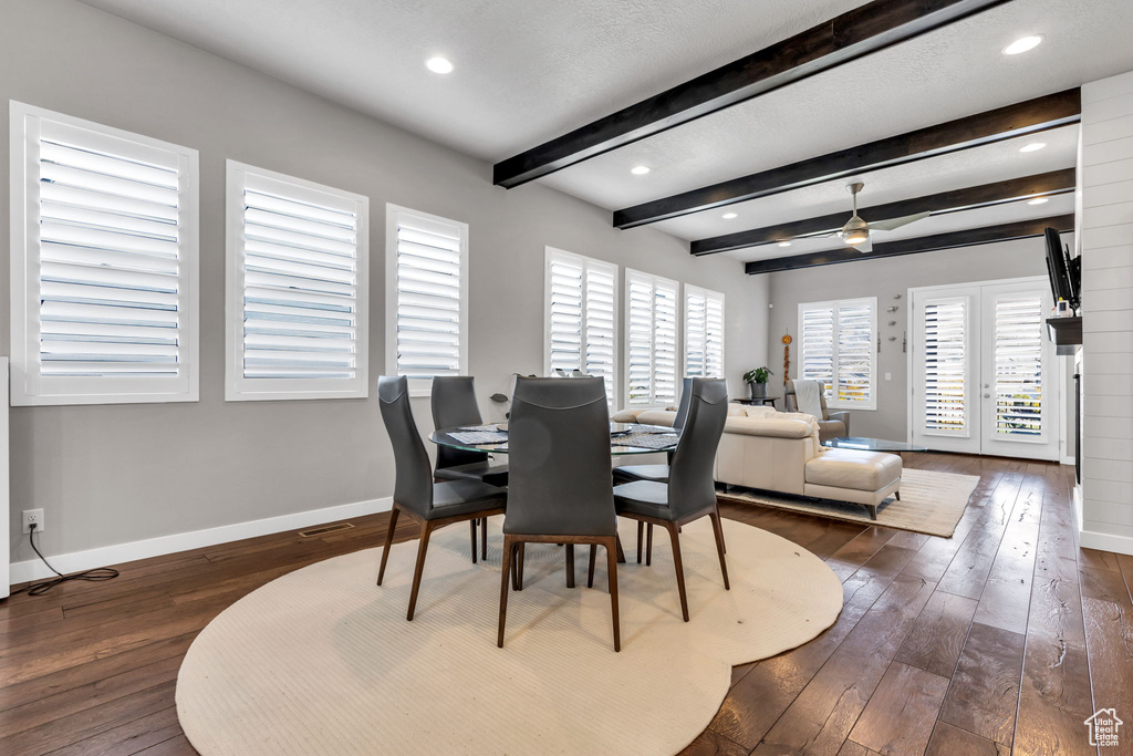 Dining room featuring dark hardwood / wood-style flooring, beamed ceiling, french doors, and ceiling fan