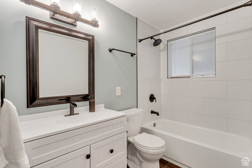 Full bathroom with toilet, tiled shower / bath combo, and oversized vanity