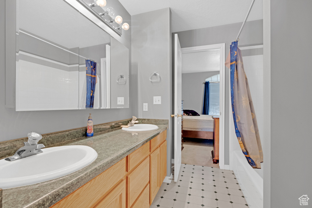 Bathroom featuring tile flooring, dual bowl vanity, and shower / tub combo with curtain