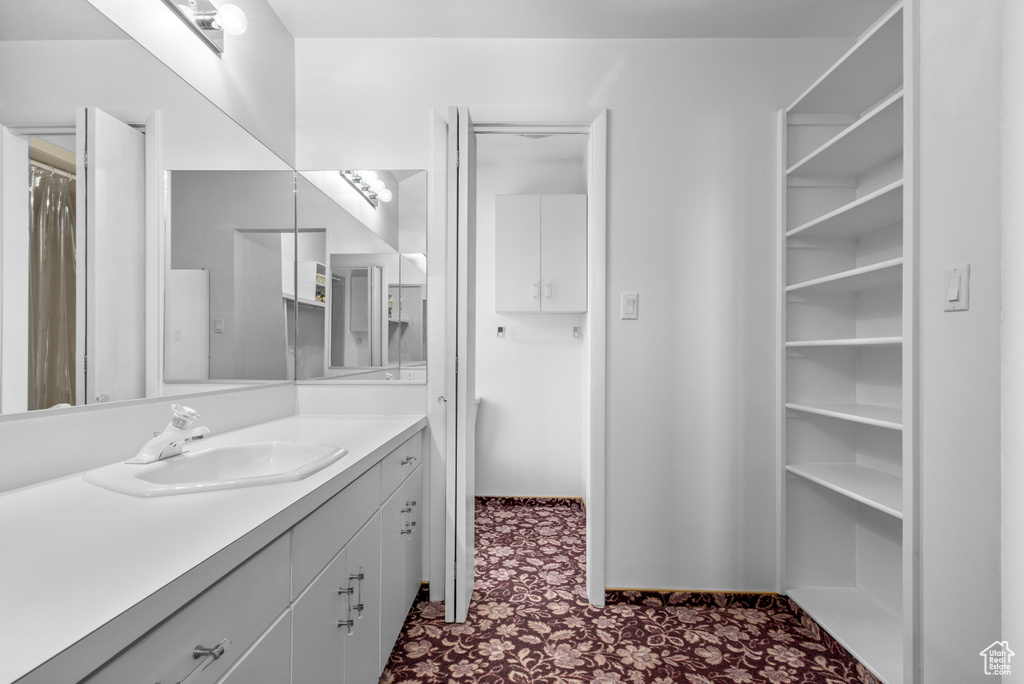 Bathroom with vanity with extensive cabinet space and tile floors
