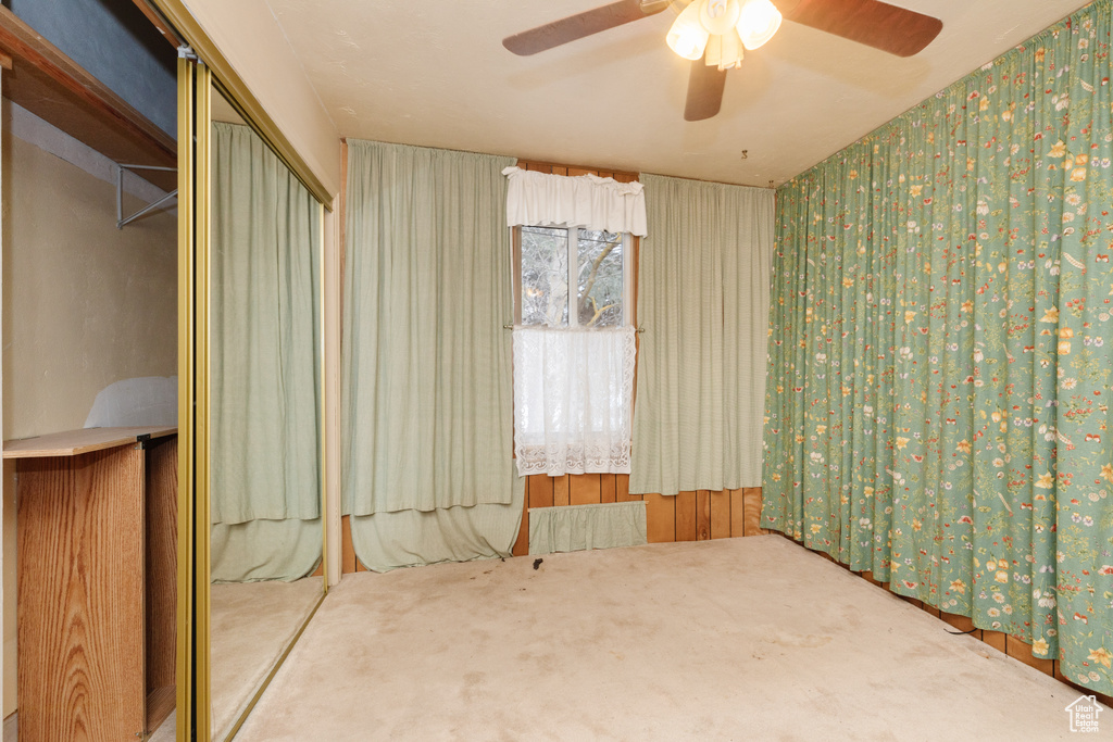 Unfurnished bedroom featuring carpet flooring, ceiling fan, and a closet