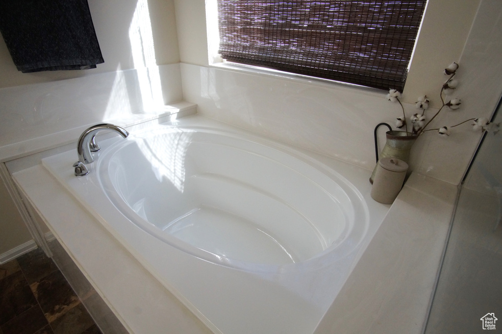 Bathroom featuring tile flooring and a tub