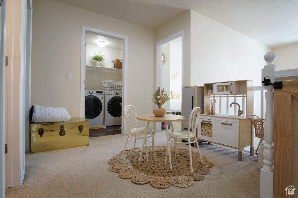 Sitting room with light colored carpet and washing machine and dryer