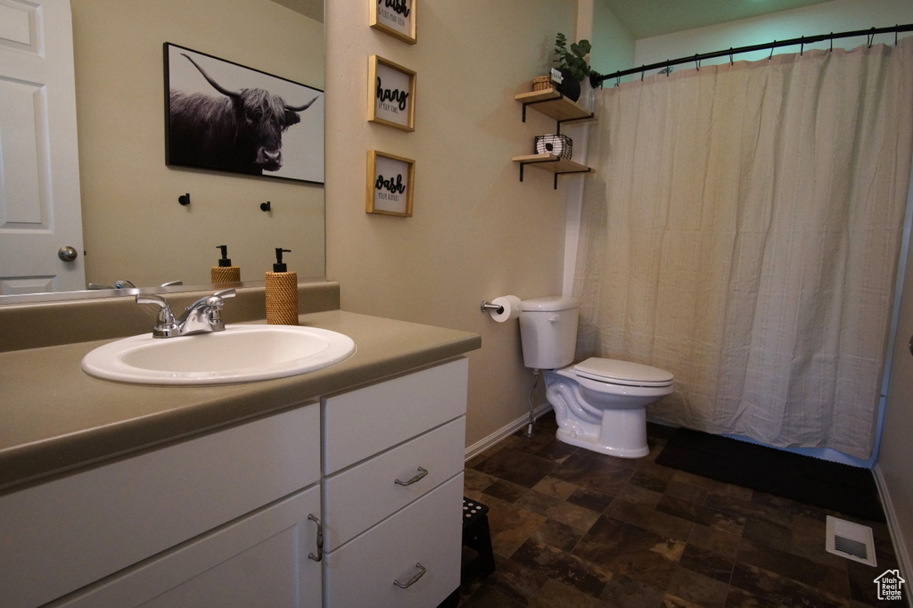 Bathroom with vanity, toilet, and tile floors