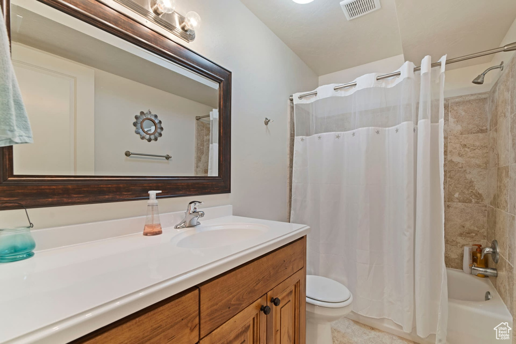 Full bathroom featuring toilet, shower / bathtub combination with curtain, large vanity, and tile flooring