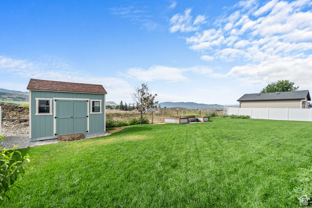 View of yard featuring a mountain view and a storage shed