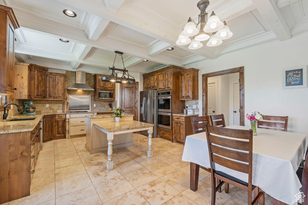 Kitchen with backsplash, a chandelier, sink, a center island, and light stone countertops