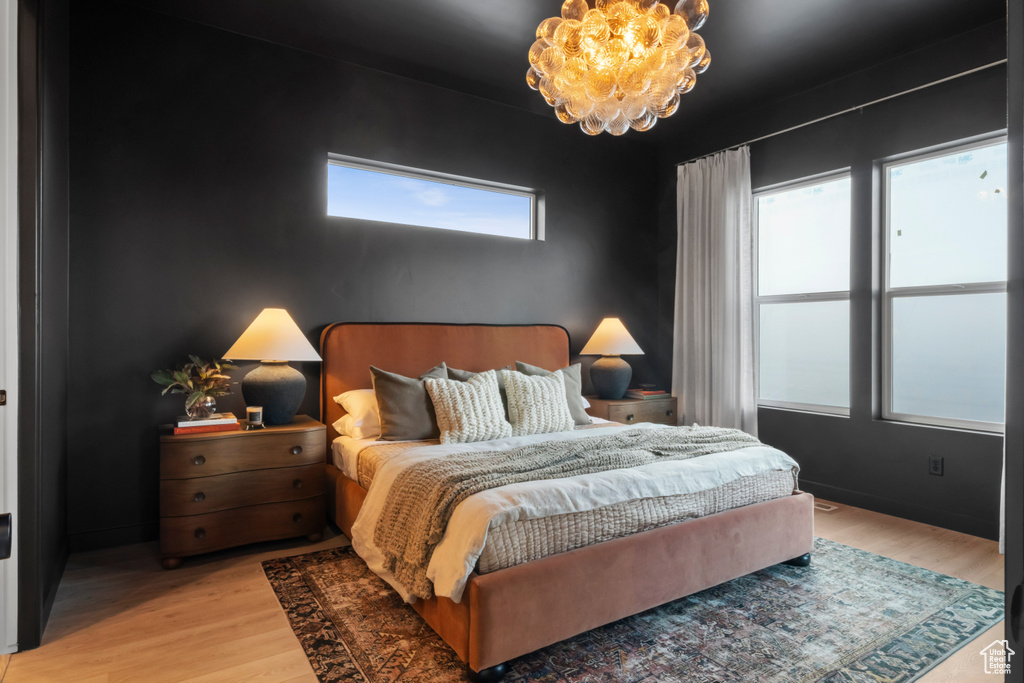 Bedroom featuring a chandelier and light hardwood / wood-style flooring