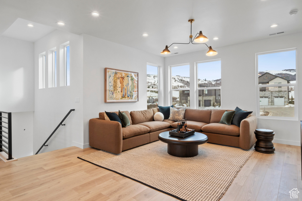 Living room featuring plenty of natural light, a notable chandelier, and light hardwood / wood-style floors