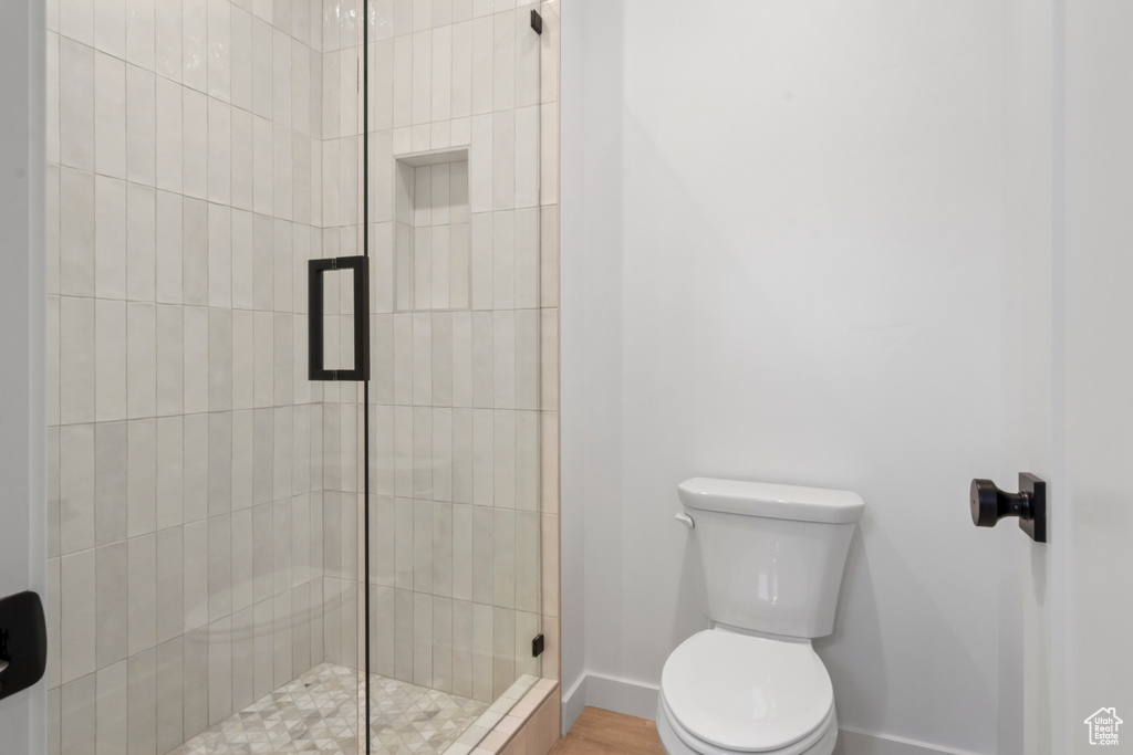 Bathroom with toilet, walk in shower, and hardwood / wood-style floors