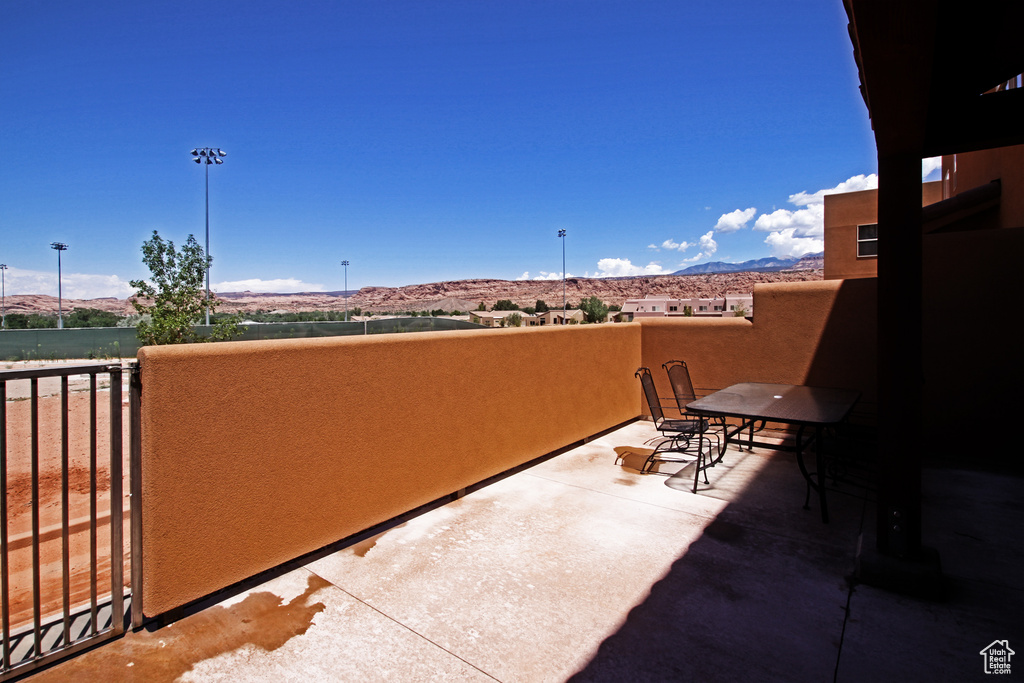 View of patio with a mountain view and a balcony